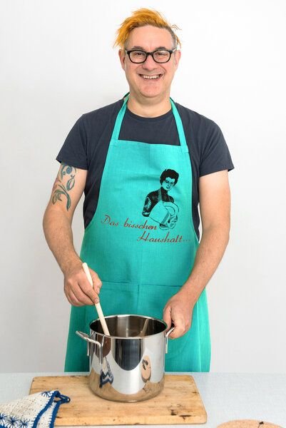 Hirschkind Bio-Kochschürze handgewebt Fair-Trade "Das bisschen Haushalt..." türkis