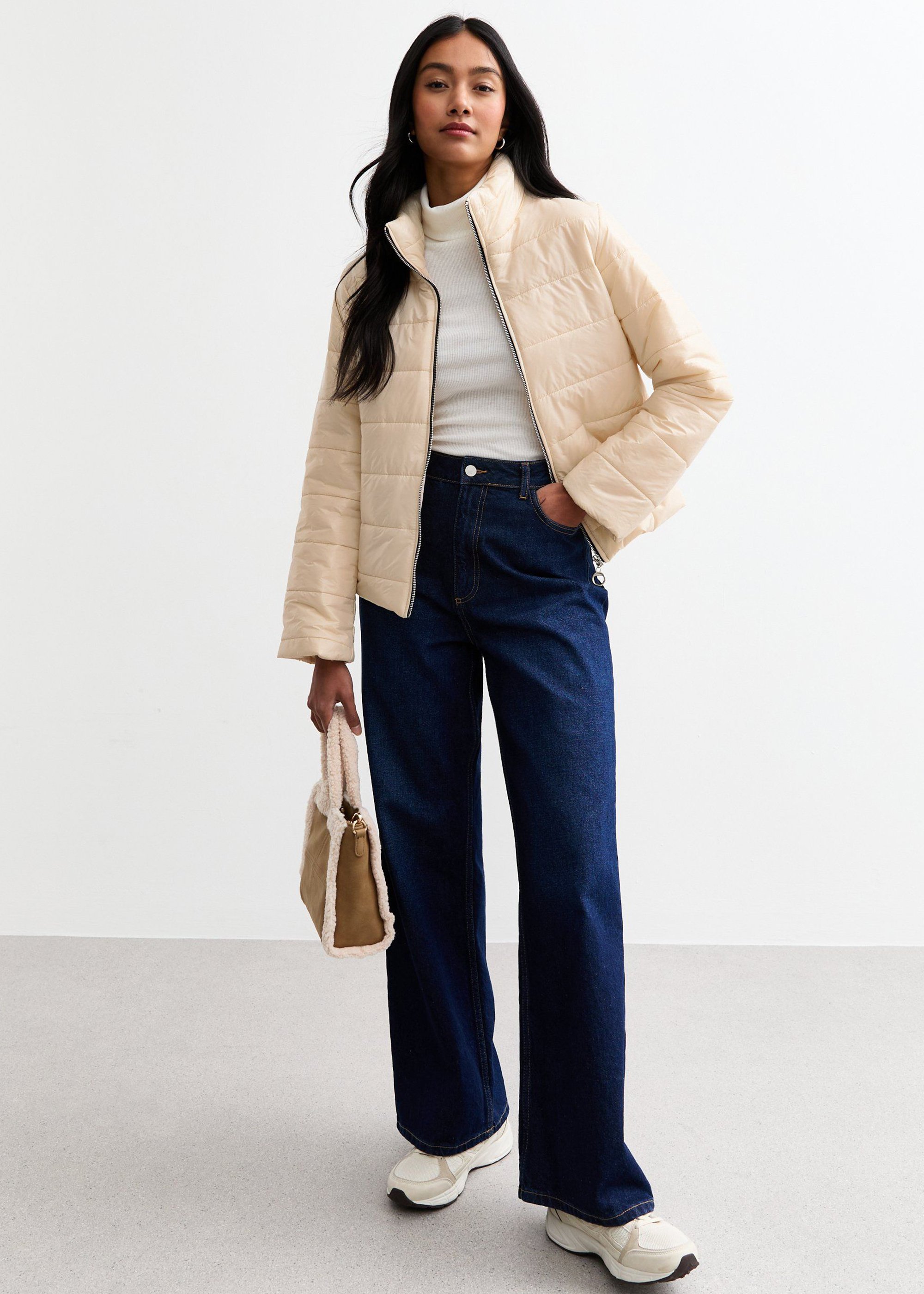 Cremefarbene, vorne mit Reißverschluss versehene, gesteppte kurze Jacke