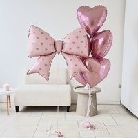 7-piece pink heart-shaped bow balloon set includes a 38-inch heart-printed bow foil balloon and an 18-inch pink heart balloon.