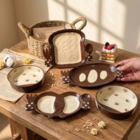 Creative hand-drawn ins-style ceramic plates in bread shapes, stylish pretzel and toast plates, snack plates and fruit plates