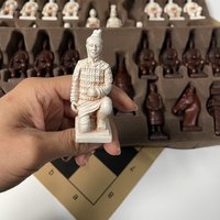 Large-scale chess game with deliberately aged three-dimensional character designs and heavy chess pieces for entertainment