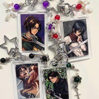 This keychain features characters from the Japanese anime/manga series *Attack on Titan*! A famous dark fantasy manga and anime.