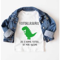 60 SECOND MAKEOVER Footballer Dinosaur T-Shirt in White | Size: 12-18 m