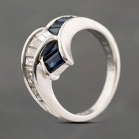 Pre-Owned Platinum 1.42ct Sapphire and 0.91ct Baguette Cut Diamond Cross Over Dress Ring 43361180