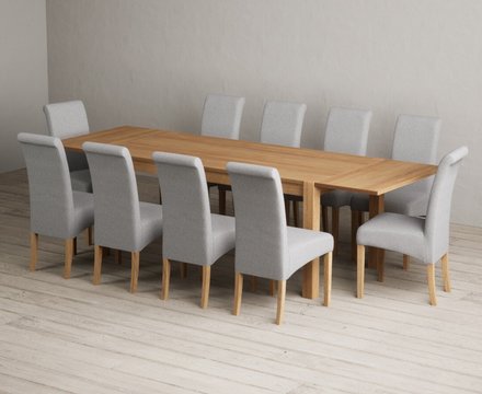 Extending thetford 180cm solid oak dining table with 10 grey scroll back chairs