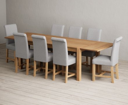 Extending thetford 180cm solid oak dining table with 8 grey braced chairs