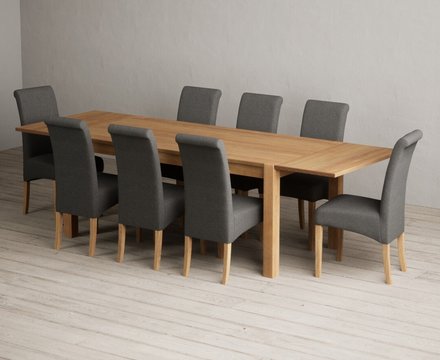 Extending thetford 180cm solid oak dining table with 8 charcoal grey scroll back chairs